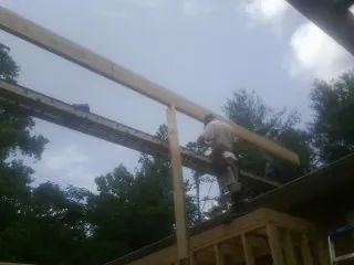Carpenter setting a ridge beam over a new addition frame — Ice Dam Removal by Roofing Brothers in Hohenwald