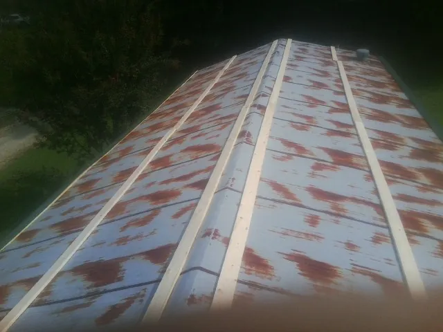 Rusted metal roof panels with new wood purlins before replacement — Storm Damage Roof Repair in Hohenwald by Roofing Brothers