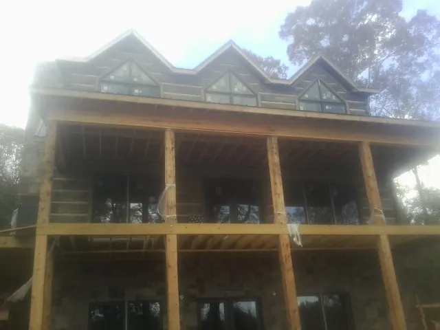 Dormers and porch framing on a large log home under construction — Roof Coating work by our crew in Hohenwald