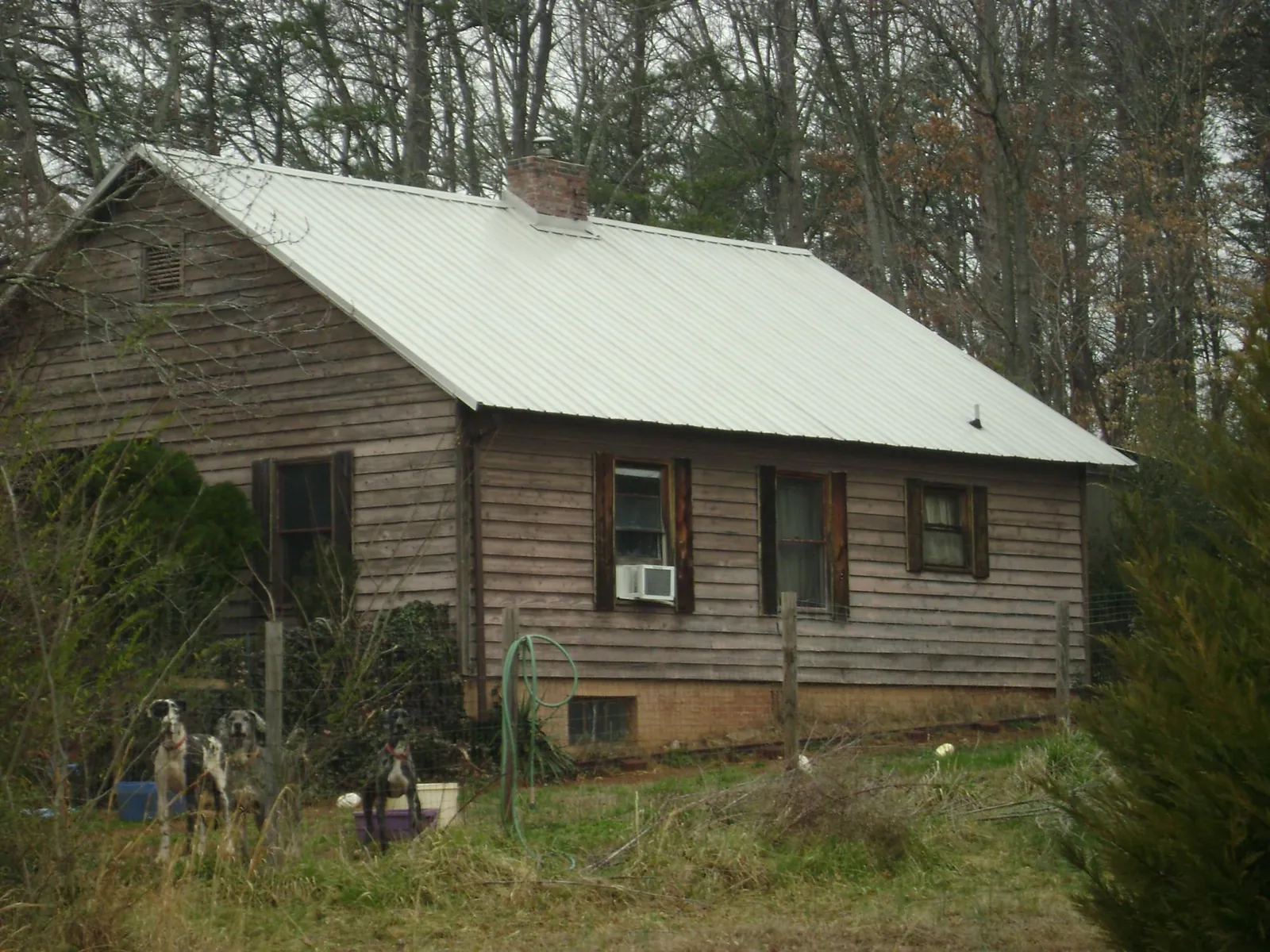White metal roof on an old wood sided farmhouse, from a Metal Roof Installation job in Hohenwald